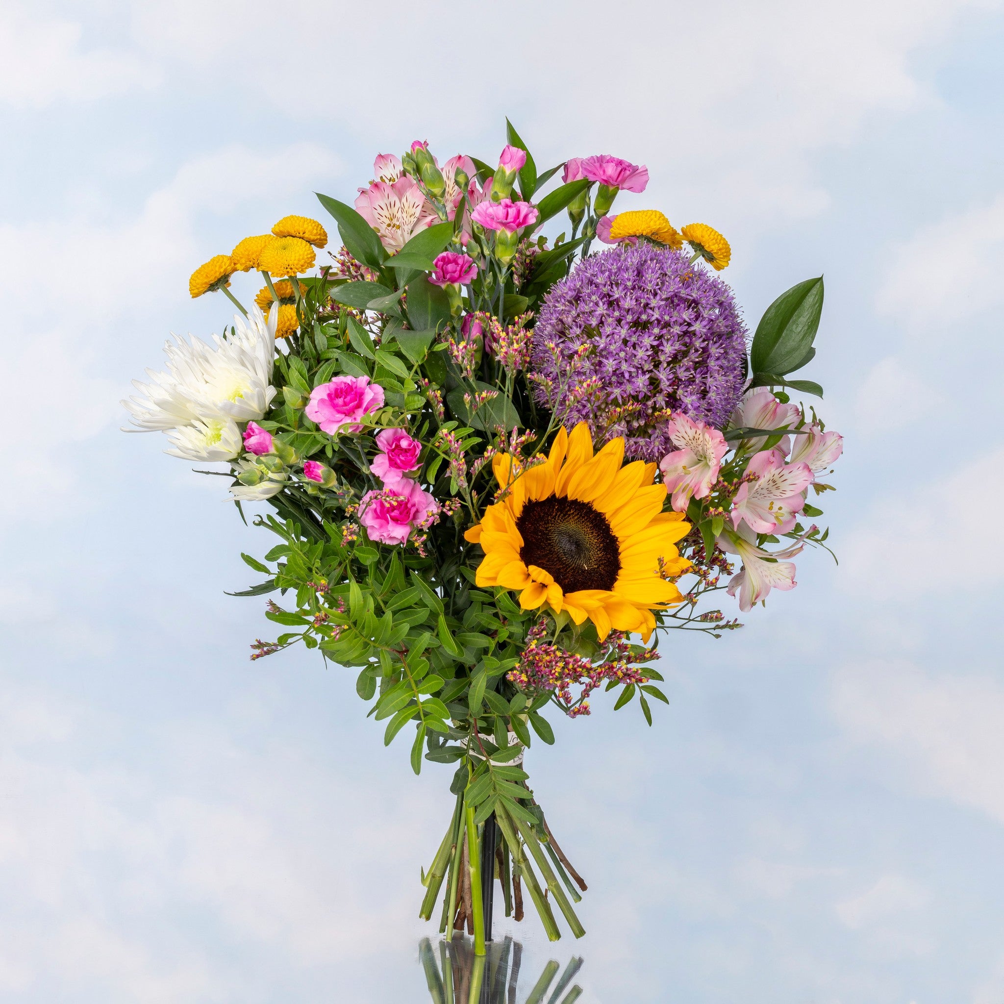 Arreglo floral con girasol y margaritas blancas, ramo luminoso que resalta la frescura y variedad del producto.